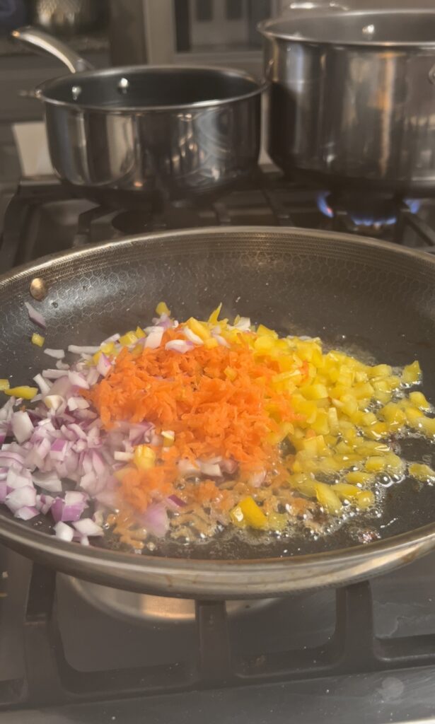 Vegetables being sautéed in a pan.